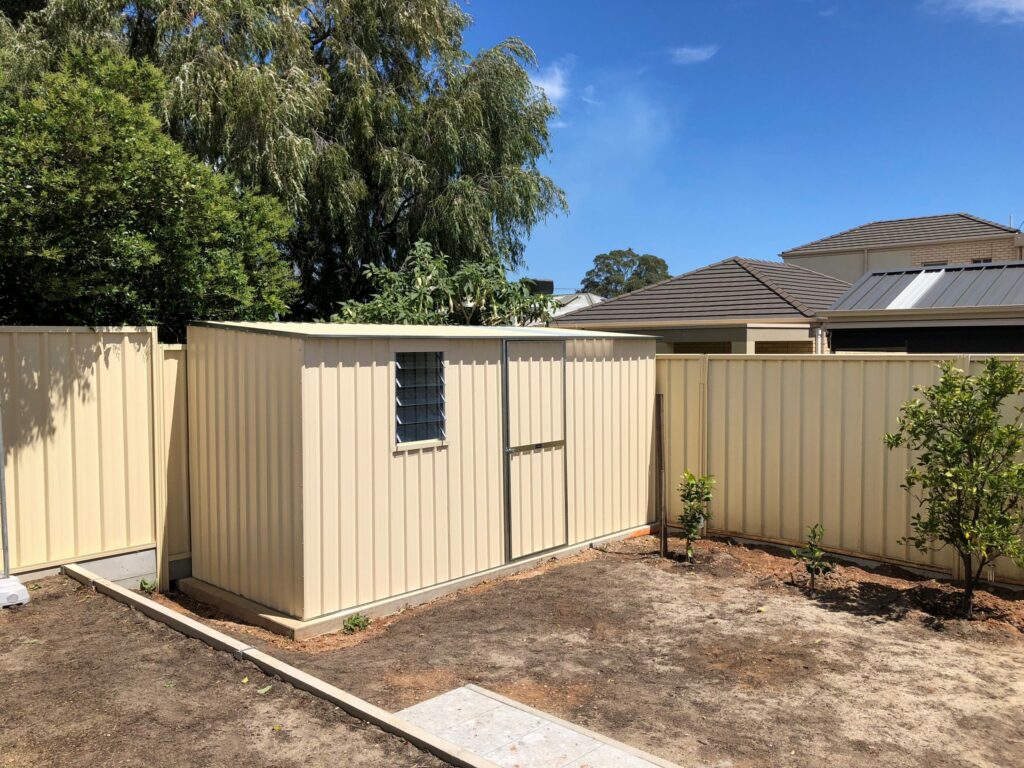 Image of a beige colored shed in the backyard